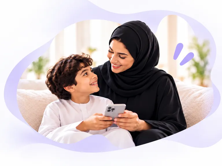 A mother and her son smiling at each other while using a phone together